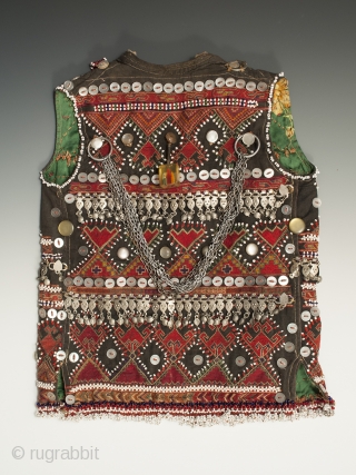 A very special child's vest from the Kohistan area of Pakistan. It is finely embroidered and extravagantly decorated with beads, buttons, and silver ornaments. There is a charming whistle on the front,  ...