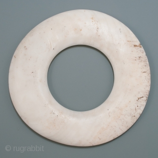 Yua currency shell ring,
Maprik area, East Sepik Province, Papua New Guinea.
Tridacna shell.
6.5" (16.5 cm) diameter.
Late 19th to early 20th century.

From the giant tridacna clam shell, currency rings were laboriously crafted with grit,  ...