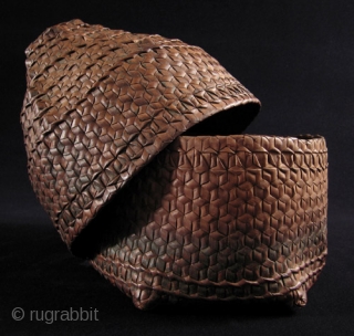 This is a beautifully shaped woven storage basket from Timor. It measures 11” high by 8” wide and has a small hole in one corner. Early 20th century.     