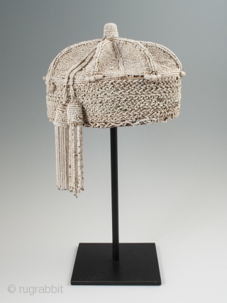 Beaded crown, Yoruba People, Nigeria. 8″ (20.3 cm) high by 7″ (17.8 cm) wide. Mid-20th century. A nice example with two tassels hanging on one side, some slight bead loss and a  ...