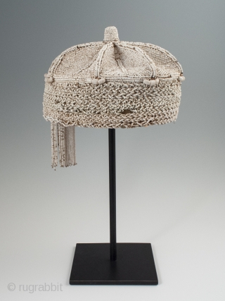 Beaded crown, Yoruba People, Nigeria. 8″ (20.3 cm) high by 7″ (17.8 cm) wide. Mid-20th century. A nice example with two tassels hanging on one side, some slight bead loss and a  ...