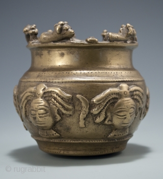 Offering bowl,
Maharashtra Province, India,
Brass,
circa 16th/17th century.
4" (10 cm) high.

This rare Shaivite sacred bowl is adorned with five representations of the dreadlocked Hindu god, Shiva. Alternating the faces are attribute objects of Shiva:  ...