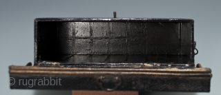 Carrying box,
Japan.
Leather, wood, metal.
Late 19th century,
8" (20.2 cm) wide by 4.5" (11.4 cm) high by 2.5" (6.3 cm) deep.
This mysterious little box was used as a carrying case for small cylindrical objects,  ...