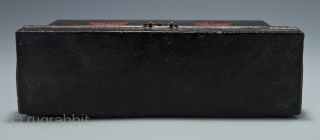 Carrying box,
Japan.
Leather, wood, metal.
Late 19th century,
8" (20.2 cm) wide by 4.5" (11.4 cm) high by 2.5" (6.3 cm) deep.
This mysterious little box was used as a carrying case for small cylindrical objects,  ...