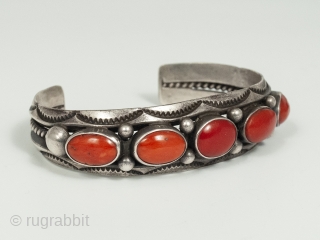 20th Century Coral and Silver Bracelet by Fred Thompson, Navajo Jeweler. Five gorgeous cabochons of rich red coral are set in silver bezels, flanked by silver beads and stamped crescents, in this  ...