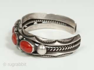 20th Century Coral and Silver Bracelet by Fred Thompson, Navajo Jeweler. Five gorgeous cabochons of rich red coral are set in silver bezels, flanked by silver beads and stamped crescents, in this  ...