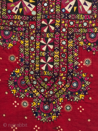 An embroidered shirt front from the Sindh region of Pakistan. Deep red cotton with some tie-dyed dots covered with silk thread embroidery and mirrored disks scattered throughout. In great condition with all  ...