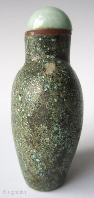 Antique Chinese Turquoise Encrusted Snuff Bottle

Antique Chinese snuff bottle of a flattened oval form with recessed foot, encrusted with finely crushed turquoise. The stopper has a jadeite lid with bright apple green  ...