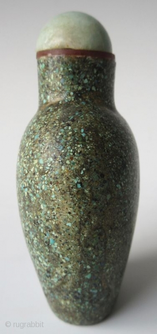 Antique Chinese Turquoise Encrusted Snuff Bottle

Antique Chinese snuff bottle of a flattened oval form with recessed foot, encrusted with finely crushed turquoise. The stopper has a jadeite lid with bright apple green  ...