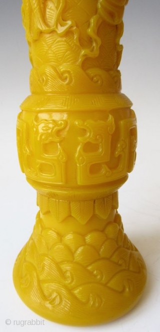 Antique Chinese Pair of Yellow Peking Glass Gu Vases

An elegant pair of Chinese monochrome yellow peking glass gu vases with relief carvings of waves, archaic scrolling serpents, one vase with a pair  ...