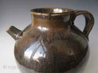 Antique Japanese Tenmoku Ware Handled Vessel


Japanese tenmoku ware ceramic vessel with ribbed handle, short front spout, and wide open top. The thick oil slick glaze stops just short above the foot left  ...
